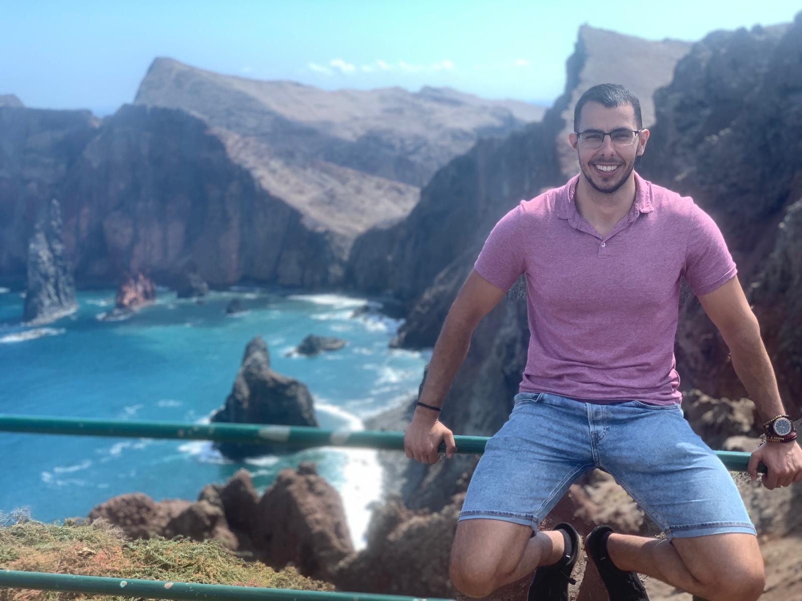 Nuno sitting with cliffs in the background